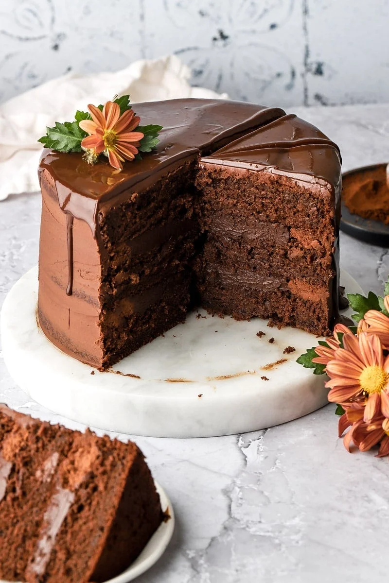 Bánh chocolate cắt lát trang trí hoa trên đĩa trắng