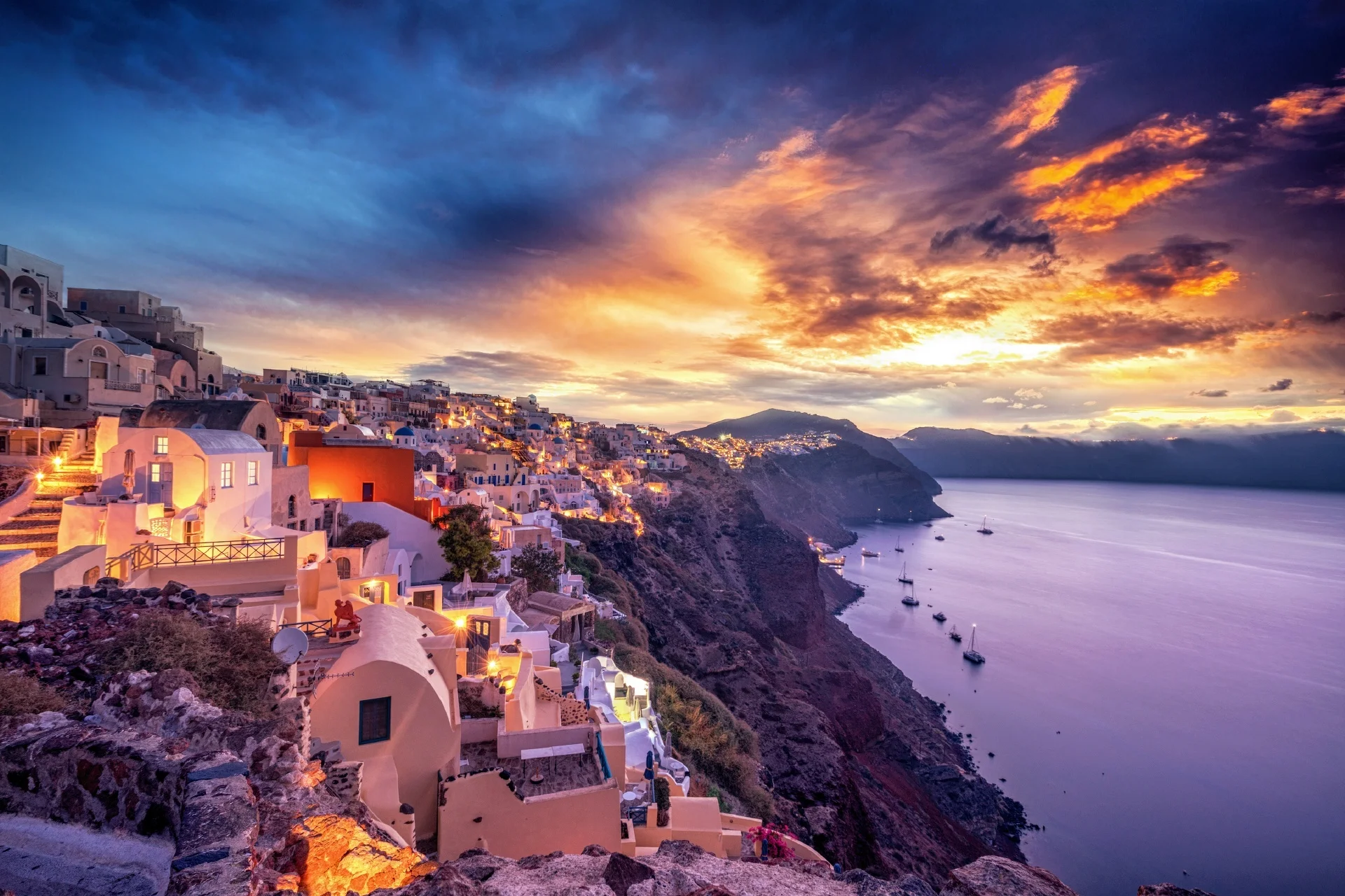 Mẫu thiệp cưới phong cách Santorini với cảnh làng ven biển trên vách đá dưới ánh hoàng hôn rực rỡ
