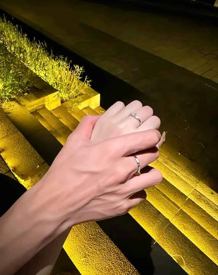 Cặp đôi nắm tay nhau dưới ánh đèn đêm