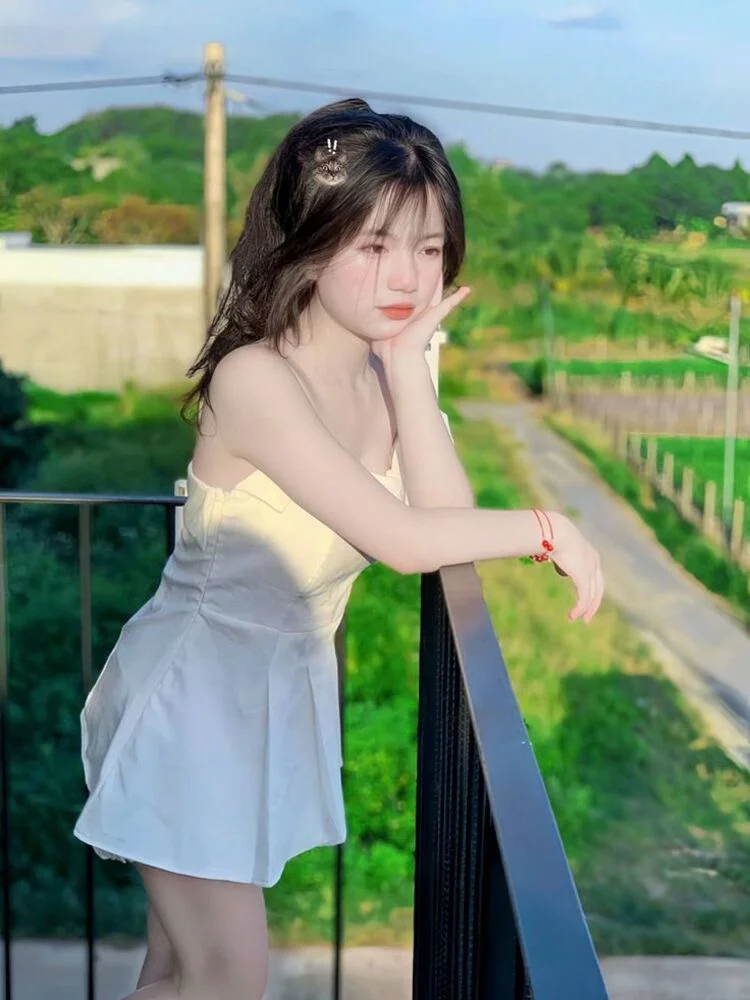 hình ảnh gái xinh mặc váy trắng đứng trên ban công